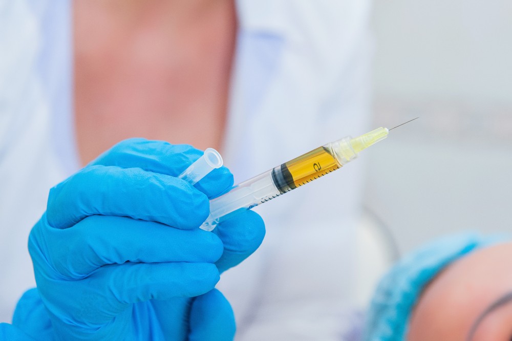 Doctor holding needle containing regenerative medicine