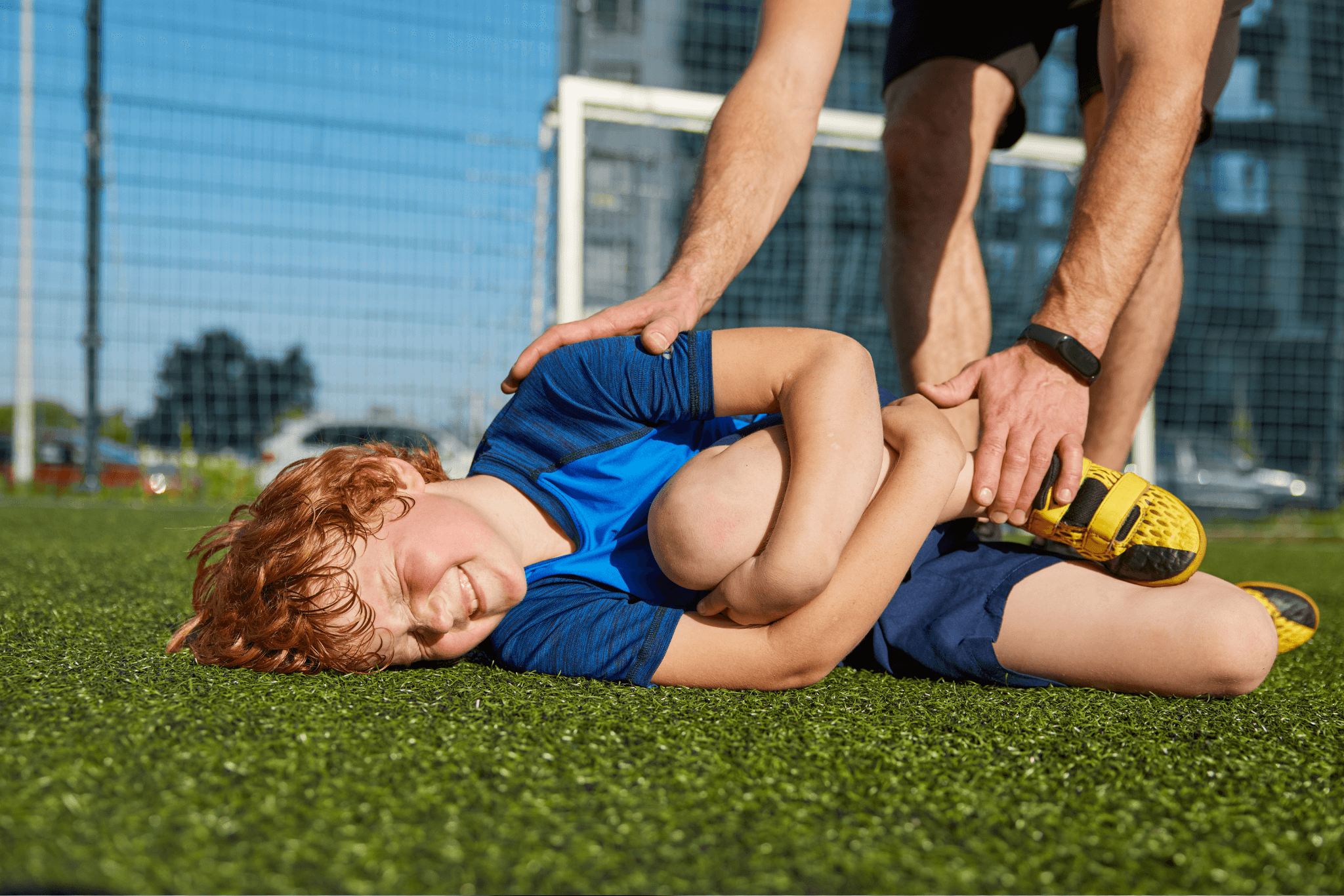 Boy child hurt his leg during training football match with father